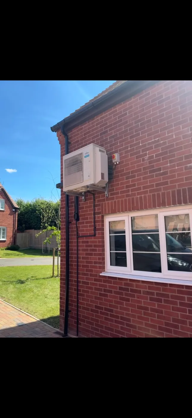 Finished outdoor air conditioning unit mounted to a brick wall