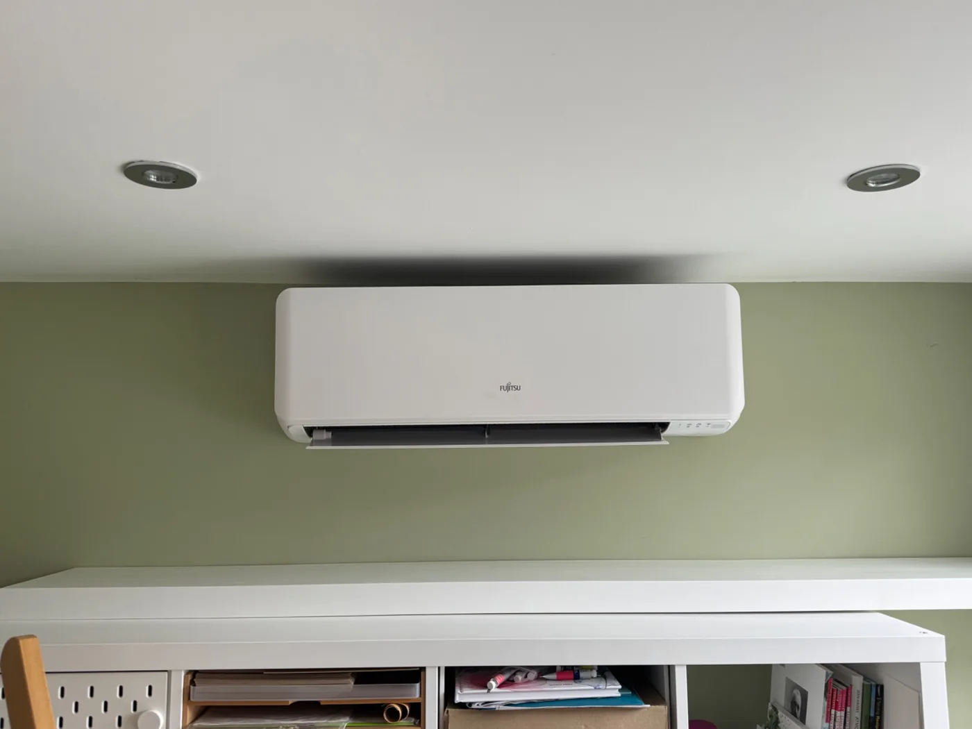 Fujitsu indoor air conditioning unit on a green wall